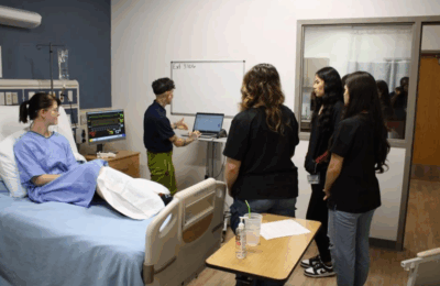 Gazette photo of instructor and high school students in a hospital room at Summer Healthcare Camp, 2025.