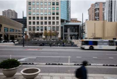 Photo of a street, pedestrians, and a bus, in Denver. Taken for The Hechinger Report